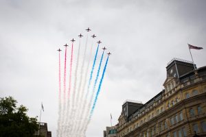 Patriotic planes flying over a building in unison